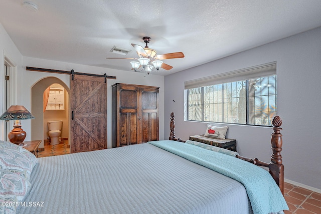 bedroom with a ceiling fan, a barn door, a textured ceiling, visible vents, and arched walkways