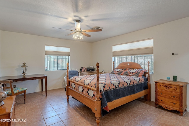bedroom featuring a ceiling fan, light tile patterned floors, a textured ceiling, and visible vents