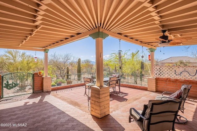 view of patio / terrace with outdoor dining area, fence, and a ceiling fan