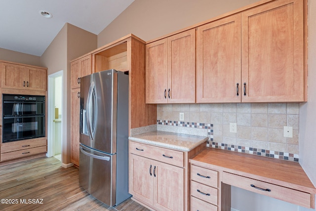 kitchen featuring light wood-style flooring, light brown cabinetry, decorative backsplash, stainless steel refrigerator with ice dispenser, and dobule oven black
