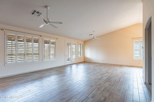 unfurnished living room featuring visible vents, baseboards, lofted ceiling, wood finished floors, and a ceiling fan