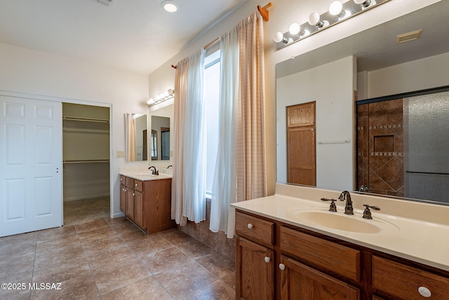full bathroom with a sink, visible vents, two vanities, and a spacious closet