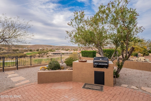 view of patio featuring an outdoor kitchen, a grill, and a fenced backyard