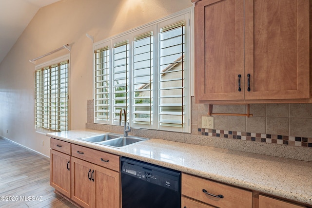 kitchen with a sink, vaulted ceiling, light wood-style floors, dishwasher, and backsplash