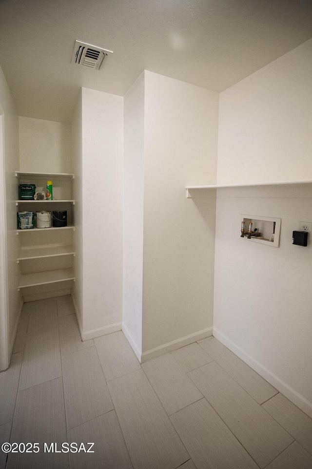 laundry area featuring laundry area, hookup for a washing machine, baseboards, and visible vents