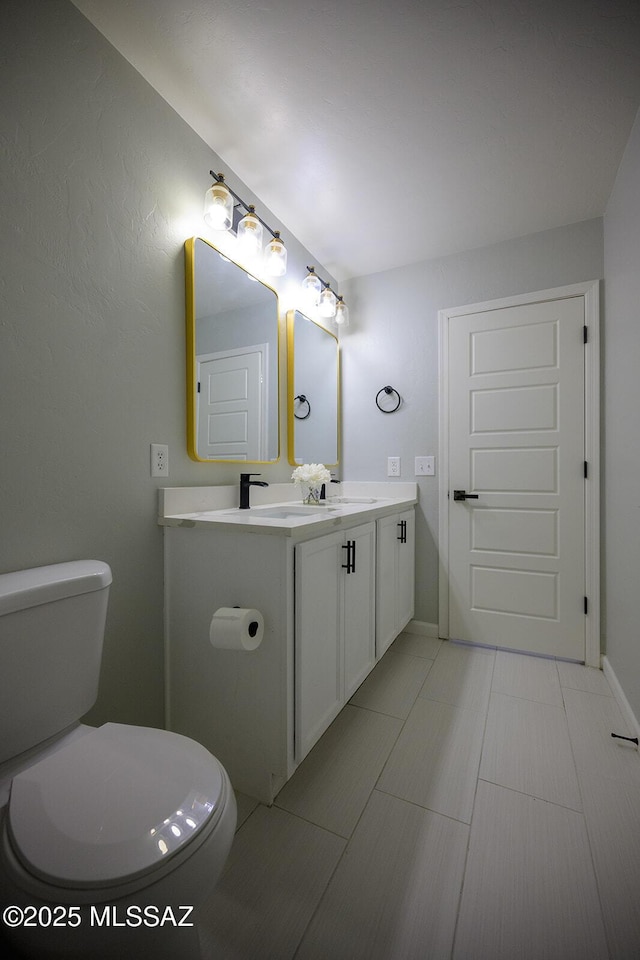 bathroom featuring a sink, toilet, and double vanity