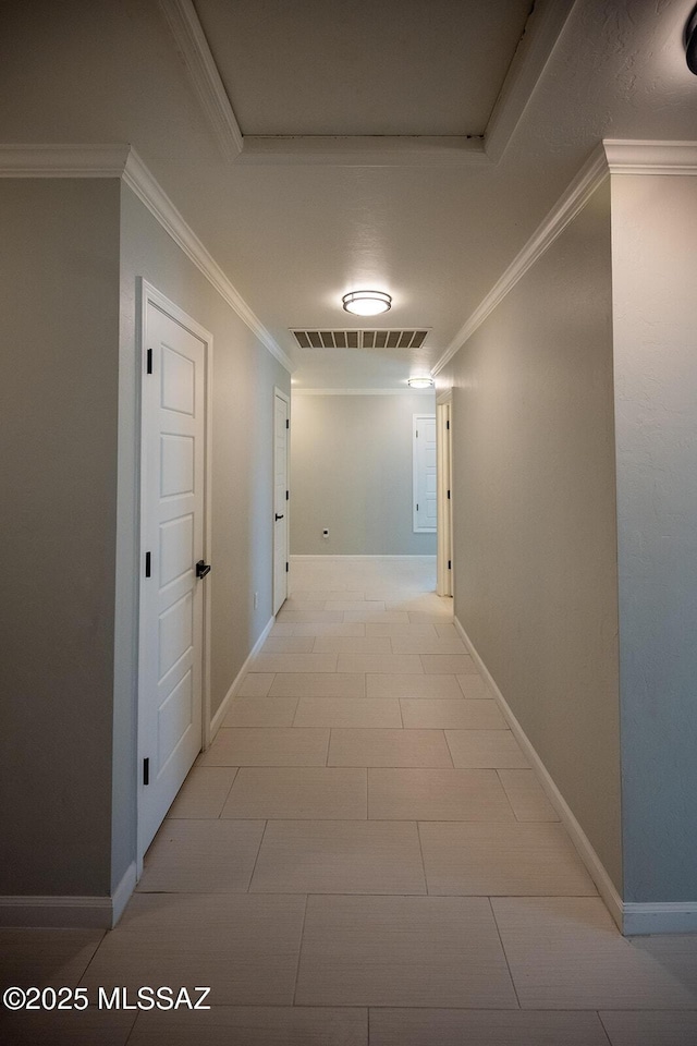 corridor featuring baseboards, visible vents, and ornamental molding