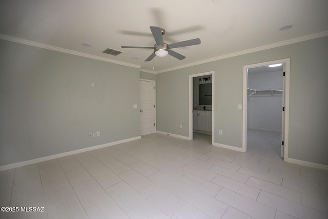 unfurnished bedroom featuring ornamental molding, a closet, baseboards, ceiling fan, and a spacious closet