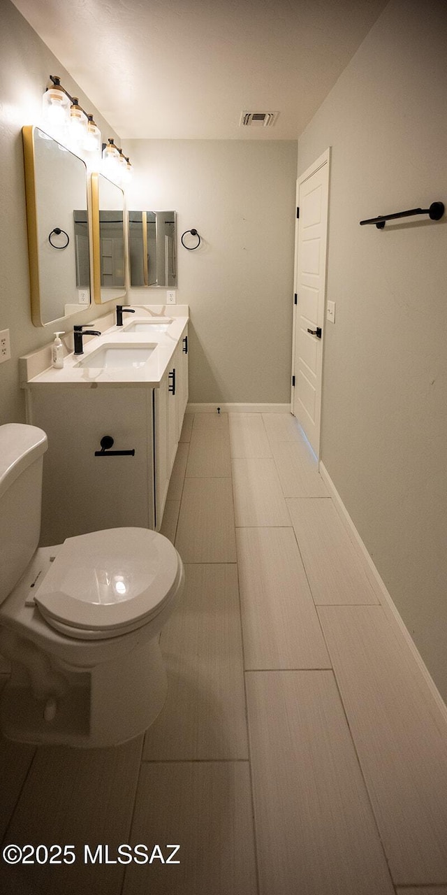 bathroom with toilet, baseboards, and a sink