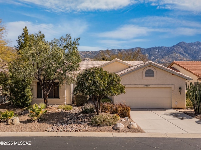 view of front of property featuring a garage, driveway, a tile roof, a mountain view, and stucco siding