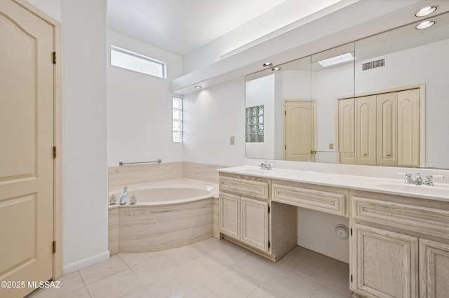 bathroom with visible vents, double vanity, a sink, and a wealth of natural light