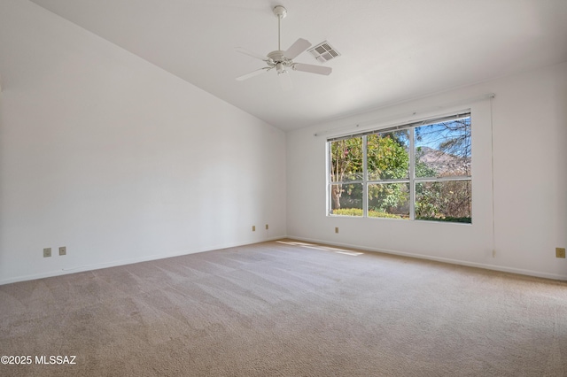 spare room with ceiling fan, light carpet, visible vents, baseboards, and vaulted ceiling
