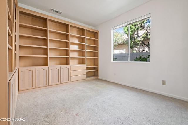 empty room featuring visible vents, light carpet, and baseboards