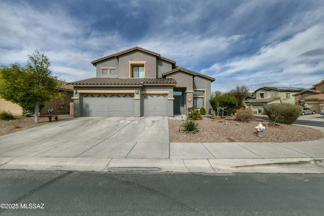 view of front of property featuring driveway, an attached garage, a tile roof, and stucco siding