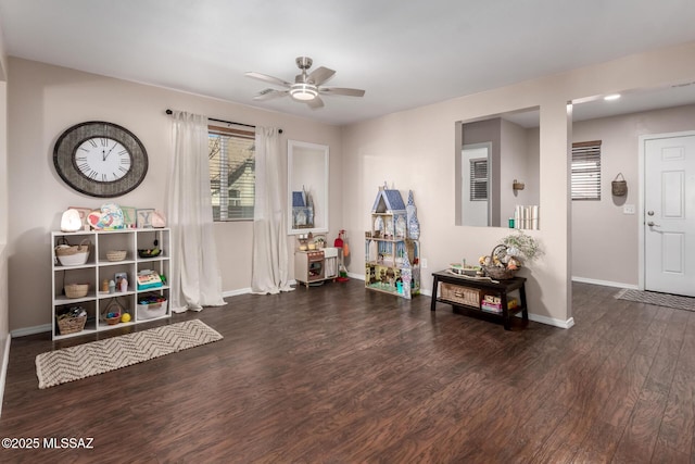 recreation room with dark wood-style floors, ceiling fan, and baseboards