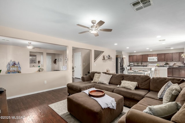 living area with dark wood-style flooring, recessed lighting, visible vents, a ceiling fan, and baseboards