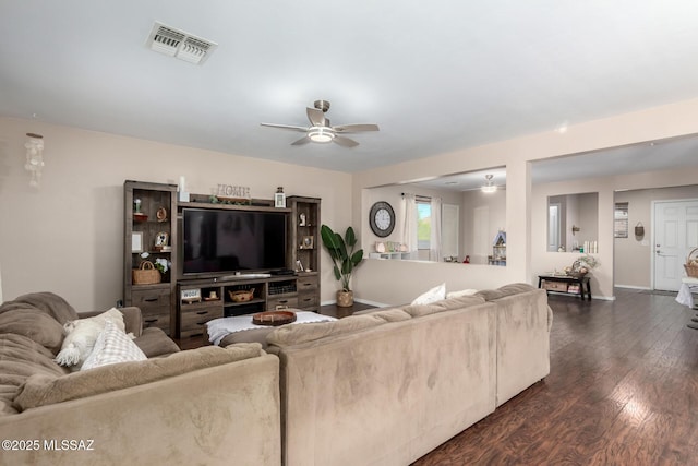 living area featuring baseboards, dark wood-type flooring, visible vents, and a ceiling fan