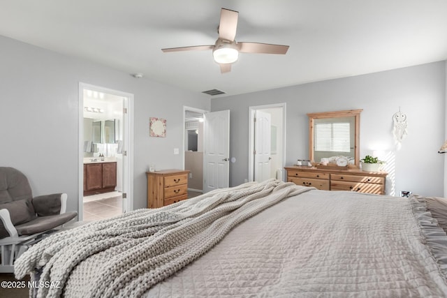 bedroom with light tile patterned floors, ensuite bath, visible vents, and a ceiling fan