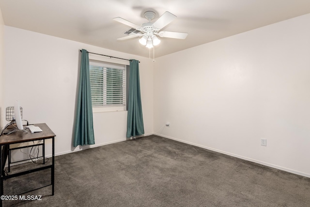 spare room with ceiling fan, baseboards, and dark colored carpet