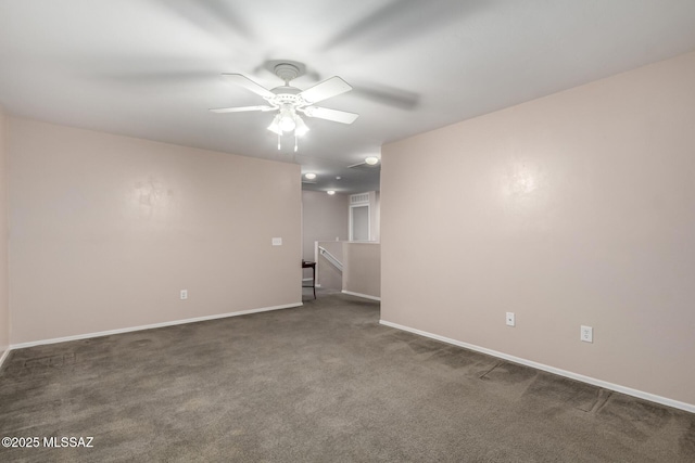 unfurnished room featuring dark colored carpet, ceiling fan, and baseboards