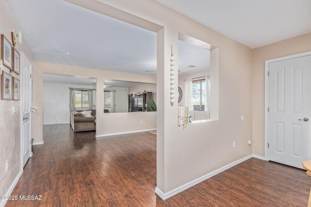 corridor featuring dark wood-style floors and baseboards