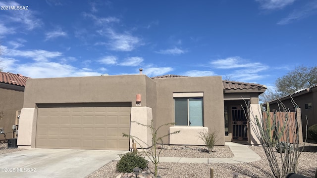 view of front of property with a garage, a tiled roof, concrete driveway, and stucco siding