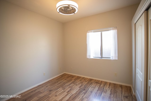 empty room with baseboards and wood finished floors