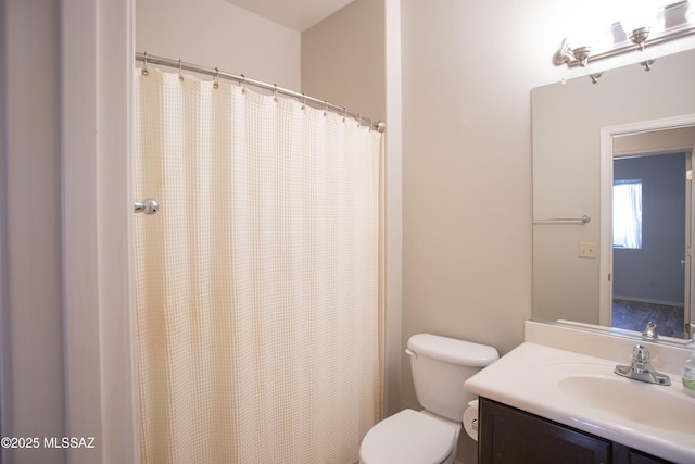 bathroom with toilet, vanity, and a shower with shower curtain