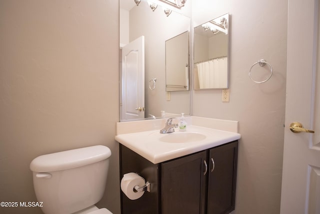 bathroom featuring toilet and vanity