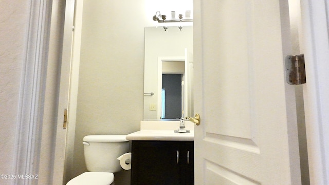 half bathroom featuring toilet and vanity