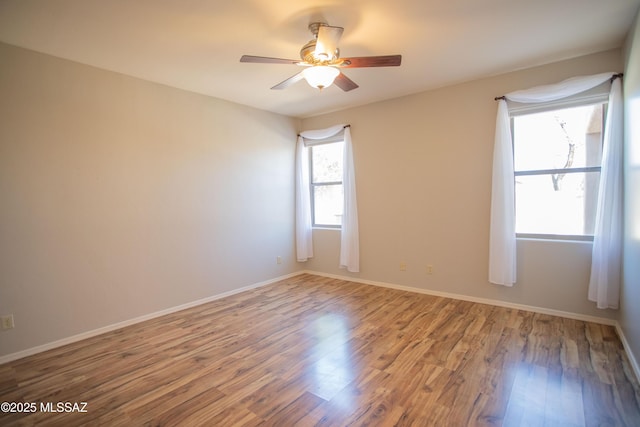 unfurnished room featuring wood finished floors, baseboards, and ceiling fan