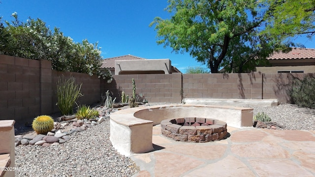view of patio featuring a fenced backyard and a fire pit