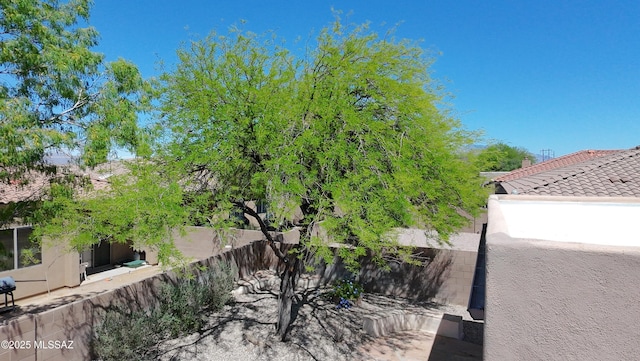 exterior space featuring fence and a tile roof