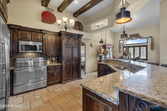 kitchen featuring a sink, visible vents, hanging light fixtures, appliances with stainless steel finishes, and dark brown cabinets