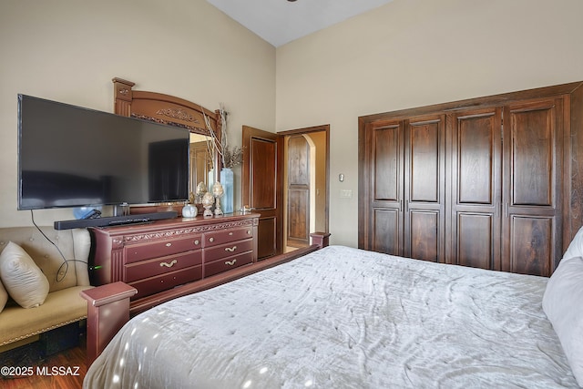 bedroom featuring dark wood-type flooring and lofted ceiling