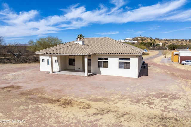 back of property featuring a patio area, a tile roof, and stucco siding