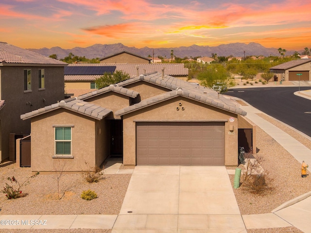 view of front of property with a mountain view, a tile roof, and stucco siding