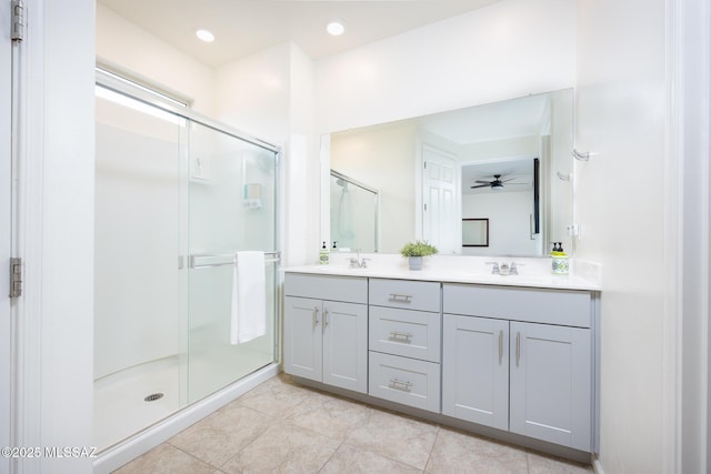 full bath with a sink, a shower stall, and double vanity