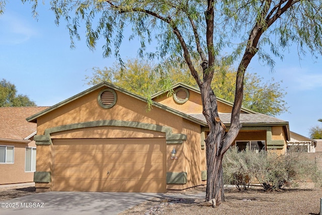 single story home featuring a garage, driveway, and stucco siding