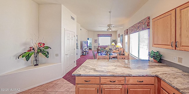 kitchen featuring a peninsula, visible vents, and ceiling fan