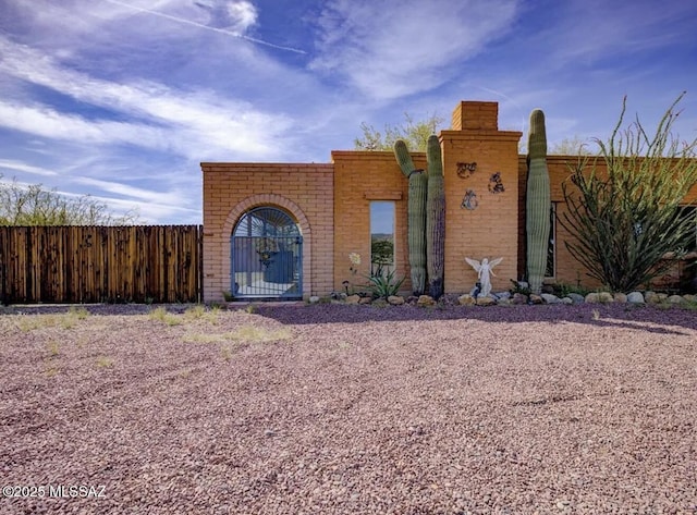 view of front of house with brick siding and fence