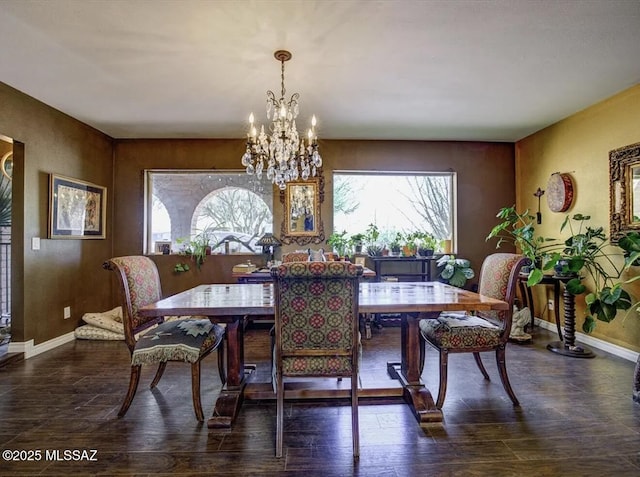 dining space featuring a notable chandelier, baseboards, and dark wood-type flooring