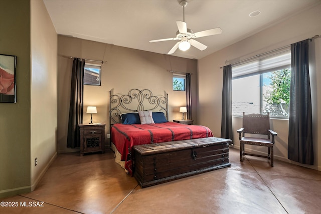 bedroom featuring finished concrete flooring, baseboards, and a ceiling fan