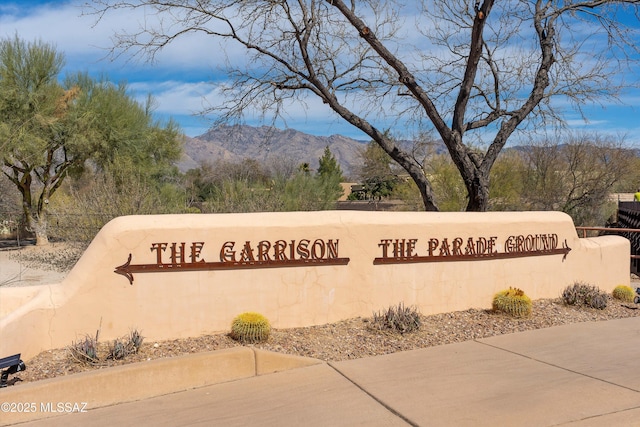 community / neighborhood sign with a mountain view