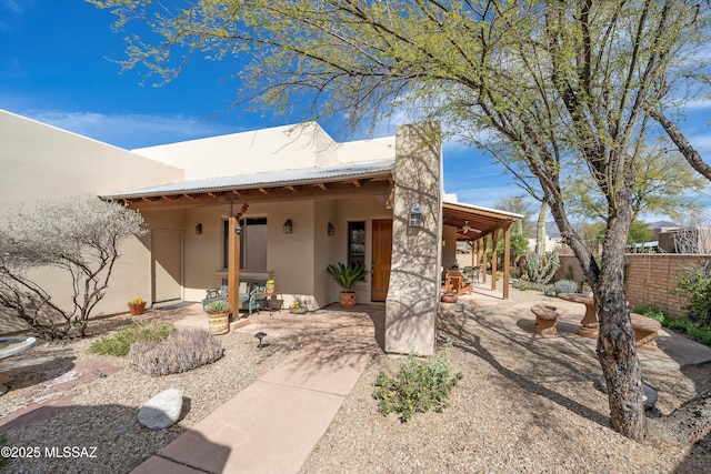 back of house featuring a patio area, fence, and stucco siding