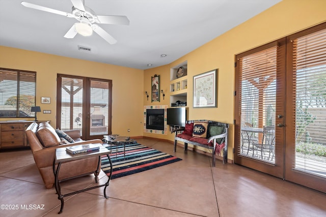 living room with french doors, a healthy amount of sunlight, visible vents, and finished concrete floors