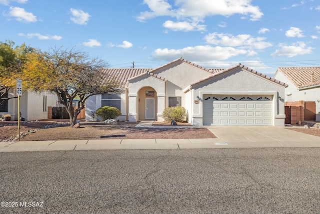 mediterranean / spanish home featuring a garage, concrete driveway, and stucco siding