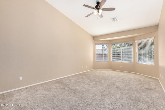 spare room featuring lofted ceiling, visible vents, light carpet, ceiling fan, and baseboards