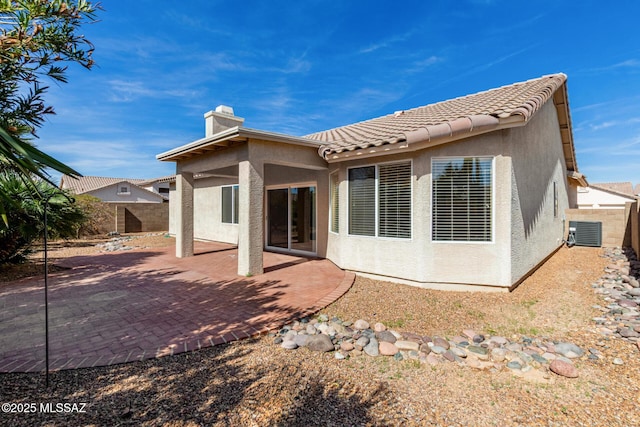 rear view of house featuring cooling unit, a patio area, a fenced backyard, and stucco siding