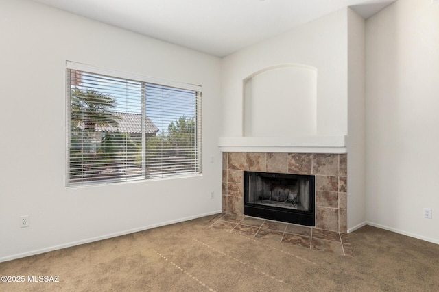 unfurnished living room with carpet floors, a fireplace, and baseboards